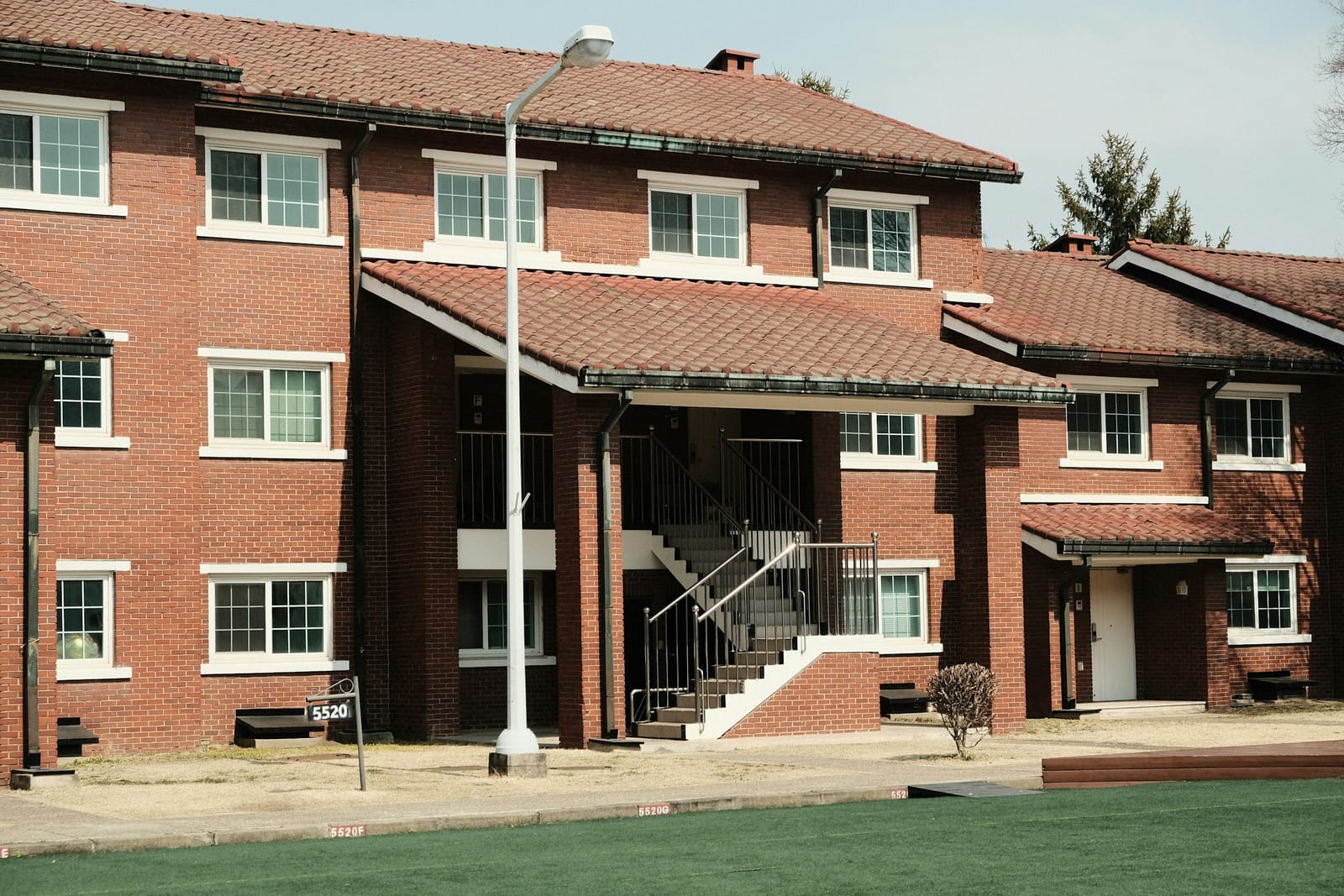 Brick apartment building with white-trimmed windows and an exterior staircase